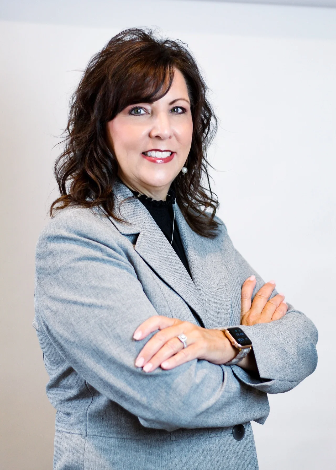 Professional headshot of a woman in a grey blazer